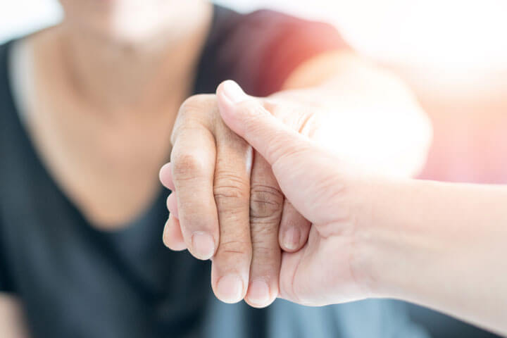  carer hand holding elder hand woman