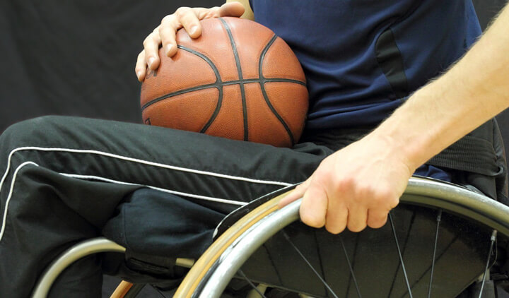 Wheelchair basketball player with ball on his lap