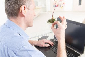 Smiling Deaf man talking using sign language on the laptop's cam